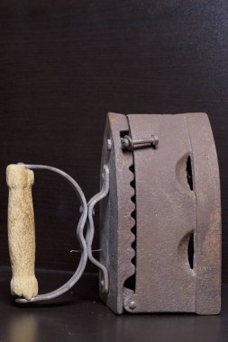 Eski demir, kömürü tarafından ısıtılır. Karanlık bir arka plan üzerinde bulunan.