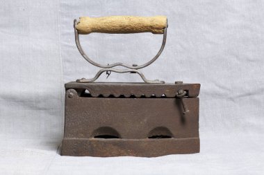 Eski demir, kömürü tarafından ısıtılır. Keten kumaş üzerinde bulunan.