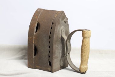 Eski demir, kömürü tarafından ısıtılır. Keten kumaş üzerinde bulunan.