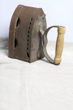 Eski demir, kömürü tarafından ısıtılır. Keten kumaş üzerinde bulunan.