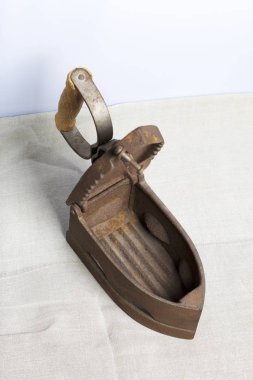 Eski demir, kömürü tarafından ısıtılır. Açılan kömür yuvası. Keten kumaş üzerinde bulunan.