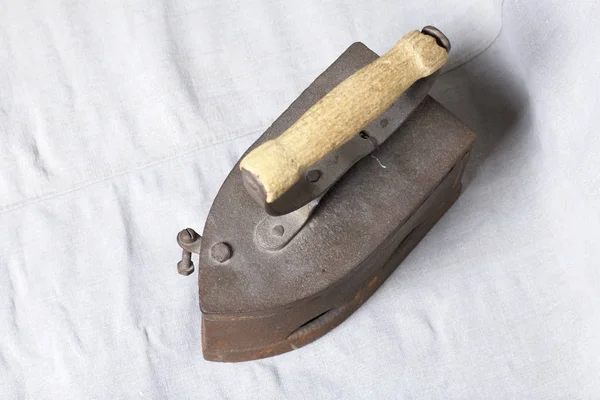 Eski demir, kömürü tarafından ısıtılır. Keten kumaş üzerinde bulunan.