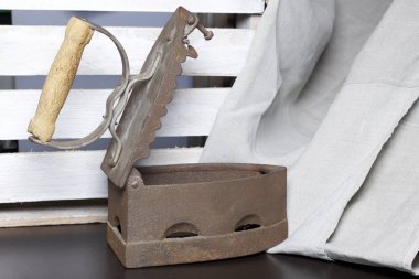 Eski demir, kömürü tarafından ısıtılır. Açılan kömür yuvası. Keten kumaş ve ahşap kutu yanında durduğunu.