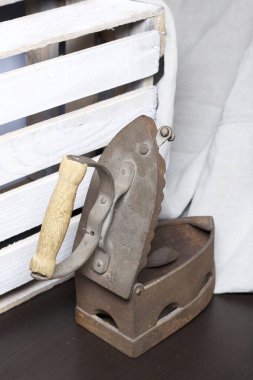 Eski demir, kömürü tarafından ısıtılır. Açılan kömür yuvası. Keten kumaş ve ahşap kutu yanında durduğunu.