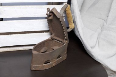 Eski demir, kömürü tarafından ısıtılır. Açılan kömür yuvası. Keten kumaş ve ahşap kutu yanında durduğunu.