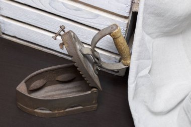 Eski demir, kömürü tarafından ısıtılır. Açılan kömür yuvası. Keten kumaş ve ahşap kutu yanında durduğunu.