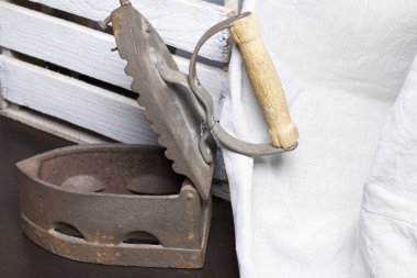 Eski demir, kömürü tarafından ısıtılır. Açılan kömür yuvası. Keten kumaş ve ahşap kutu yanında durduğunu.