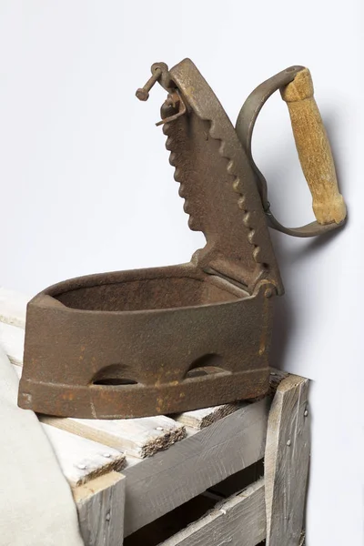 Eski demir, kömürü tarafından ısıtılır. Açılan kömür yuvası. Üzerinde bulunan bir ahşap kutu.