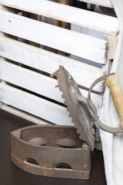 Eski demir, kömürü tarafından ısıtılır. Açılan kömür yuvası. Keten kumaş ve ahşap kutu yanında durduğunu.