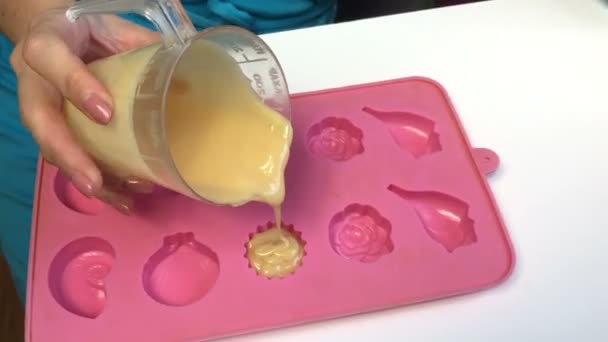 该妇女添加一个溶解的明胶与炼乳混合到硅胶模具 果冻甜食 — 图库视频影像