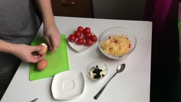 Een Man Reinigt Gekookte Eieren Vanuit Shell Salade Van Krab — Stockvideo