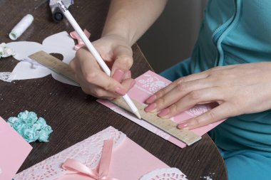 Kağıt, karton ve teyp tebrik kartları yapmak. Kadın esnaf bir biçimlendirme bir kalem ile yapar..