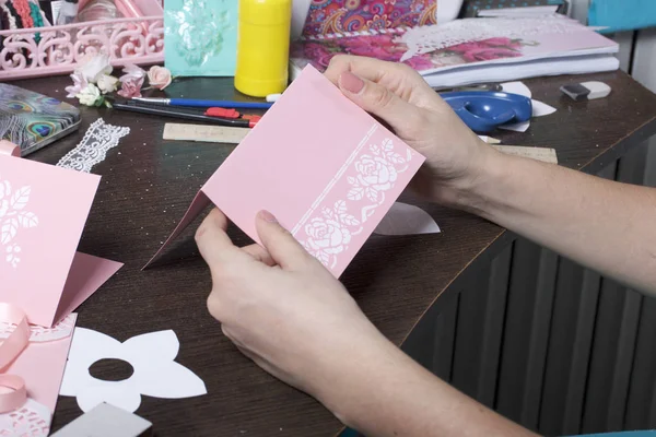 Making greeting cards from paper, cardboard and tape. Woman artisan at work.