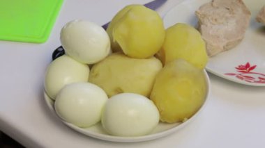 Tablo yüzeyinde salata için malzemeler. Et salatası yumurta, patates, salatalık ve bezelye ile pişirme.