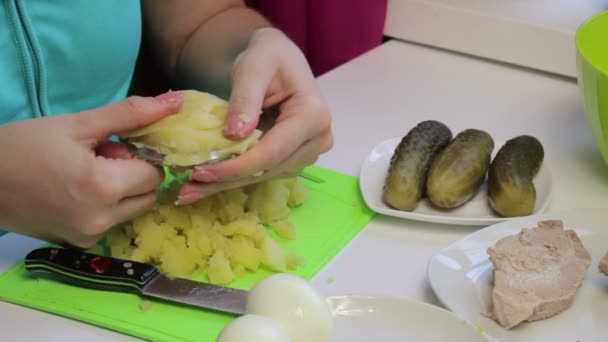 女人切煮土豆 桌子表面的沙拉的原料 烹饪肉类沙拉配鸡蛋 黄瓜和豌豆 — 图库视频影像