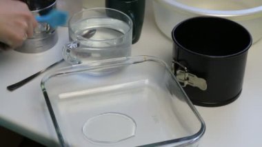 Bir kadın bir ekmek yemek pişirme ayçiçek yağı ile smear. Mutfak fırçayı kullanır. Ekmek pişirme.