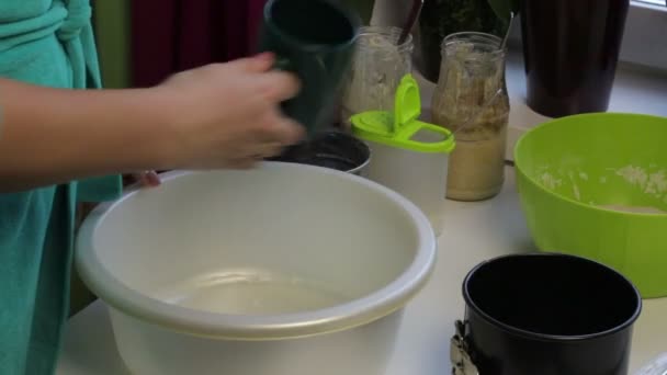 一个女人把盐加到碗里 在碗里揉面团 在家做面包 — 图库视频影像