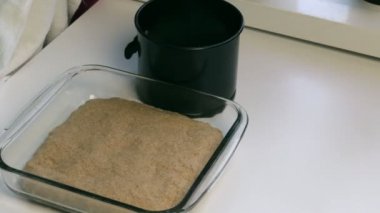 Kadın teneke pişirme bir havlu ile kapsar. Hamur formlarda yatıyor. Ekmek pişirme.