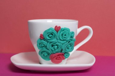 Kupa, polimer kil yapılan çiçeklerle süslenmiş. El sanatları polimer Clay. Polimer kil yapılan sıva ile dekore edilmiş kupa