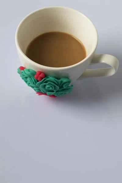 Coffee mug decorated with polymer clay flowers. Crafts from polymer clay. Mug decorated with stucco made of polymer clay