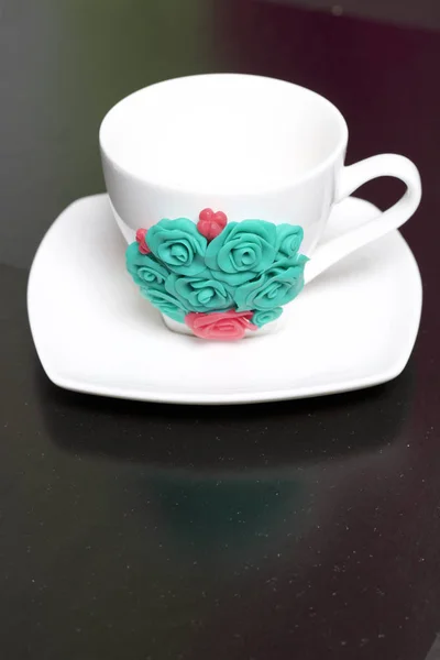 Mug, decorated with flowers made of polymer clay. Crafts from polymer clay. Mug decorated with stucco made of polymer clay