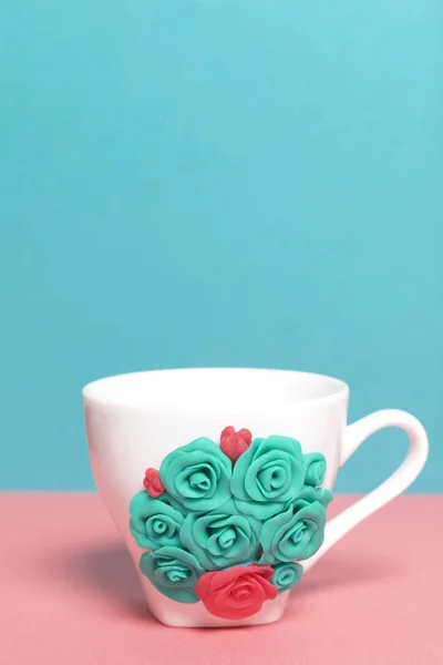 Mug, decorated with flowers made of polymer clay. Crafts from polymer clay. Mug decorated with stucco made of polymer clay