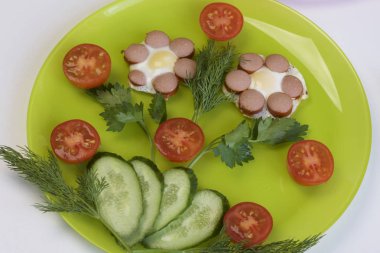 Kahvaltı sosis, bıldırcın yumurtası, otlar ve sebze.