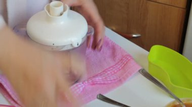  Bir kadın bir blender kapatır ve candy yapmak için maddeler pirzola.