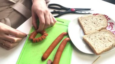 Kadın yemek. Sosis dilimleri. Kahvaltı sosis, bıldırcın yumurtası, otlar ve sebze. Masaya unsurlarıdır.