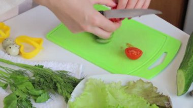 Kadın yemek. Domates dilimleri. Kahvaltı sosis, bıldırcın yumurtası, otlar ve sebze. Masaya unsurlarıdır.