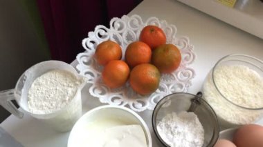 Bisküvi rulo pişirme ricotta ve mandarin ile doldurulmuş. Yemek pişirmek için malzemeler tablo yüzeyinde yer alır.