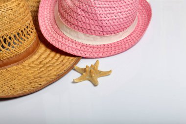 Yaz tatili için aksesuarlar. Güneş şapka ve beyaz zemin üzerine deniz yıldızı.