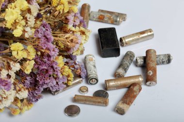 Atık pil ve solmuş çiçekler. Atık pillerin geri dönüşümü. Çevre koruma. Dünya günü.