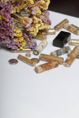 Atık pil ve solmuş çiçekler. Atık pillerin geri dönüşümü. Çevre koruma. Dünya günü.