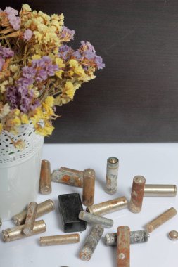 Atık pil ve solmuş çiçekler. Atık pillerin geri dönüşümü. Çevre koruma. Dünya günü.