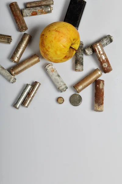 Použité baterie a vybledlé apple. Recyklace odpadních baterií. Ochrana životního prostředí. Den země. — Stock fotografie