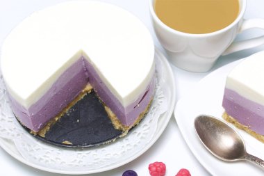 Yaban mersinli cheesecake. Bir uçan daire üzerinde hazır tatlı bir parça. Jöle katmanları farklı renklerde görülebilir.