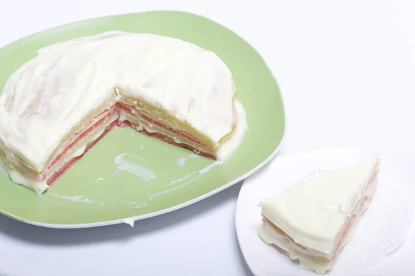 Cocinar el pastel con crema de mascarpone. El pastel terminado, untado con impregnación, yace en el plato. Las capas de color son visibles . — Foto de Stock