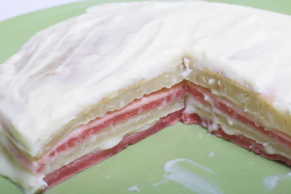 Koken de taart met mascarpone crème. De afgewerkte taart, besmeurd met impregnering, ligt op de plaat. Kleur lagen zijn zichtbaar. — Stockfoto