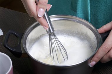 Süt jöle yemek. Pasta Bisküvi kırıntıları ve süt jöle yemek. Tablo yüzeyinde malzemeler ve mutfak aletleri vardır.