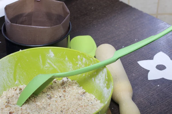 Cooking a cake of biscuit crumbs and milk jelly. On the surface of the table are the ingredients and cooking utensils. — Stock Photo, Image