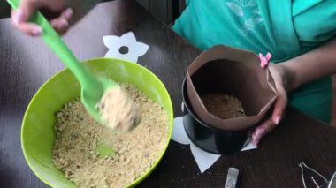 Kadın kalıp kırıntıları ekleyin. Yemek kek bisküvi kırıntıları ve süt jöle.