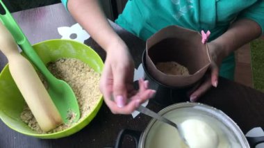 Kadın kalıp krema ekleyin. Yemek kek bisküvi kırıntıları ve süt jöle.