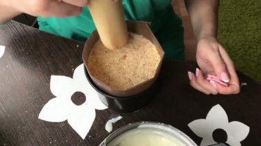 Kadın pandispanya kek kalıp için ekler. Ahşap bir oklava ile katman mühürler. Yemek kek bisküvi kırıntıları ve süt jöle.