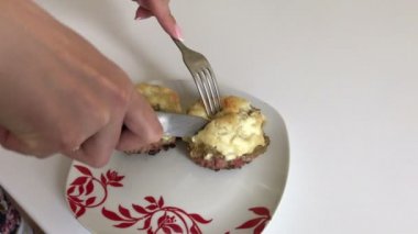 Kadın bitmiş çanak keser. Kıyma biftek patates, yumurta ve peynir ile. Pişirme adımları ve malzemeler.