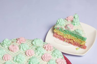 Parça kesilir ve bir daire üzerinde yan yana yatıyor. Krem yapılan gözleme pasta kek batırılmış. Krem çiçeklerle süslenmiş.