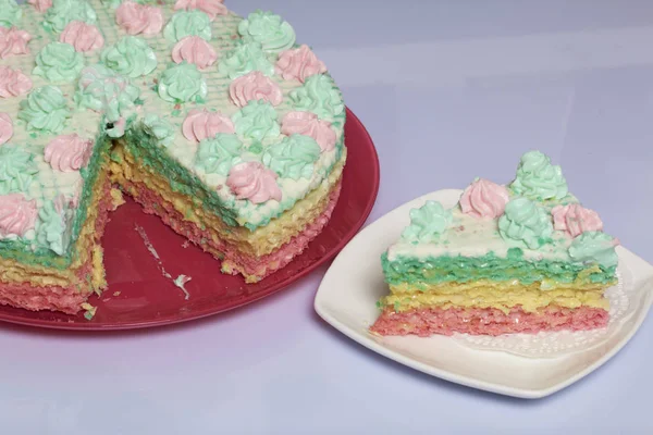 Кусок отрезан и лежит бок о бок на блюдце. Вафельный торт из сливочных тортов. Украшенные сливочными цветами . — стоковое фото