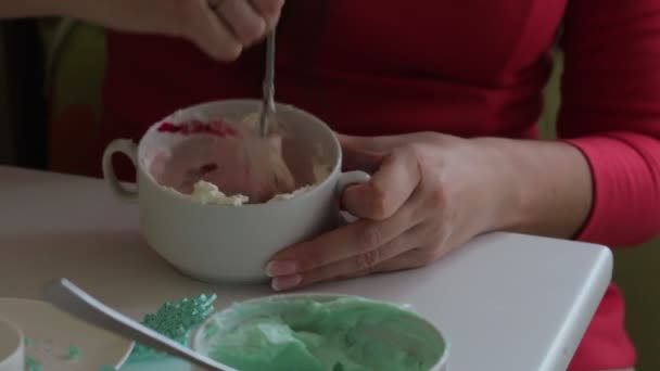 女性は 食品着色料とクリーム チーズをミックスします 前に制服の色を与えています ケーキの潤滑クリームを着色 — ストック動画