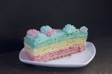 Parça kesilir ve bir daire üzerinde yan yana yatıyor. Krem yapılan gözleme pasta kek batırılmış. Krem çiçeklerle süslenmiş.