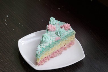 Parça kesilir ve bir daire üzerinde yan yana yatıyor. Krem yapılan gözleme pasta kek batırılmış. Krem çiçeklerle süslenmiş.